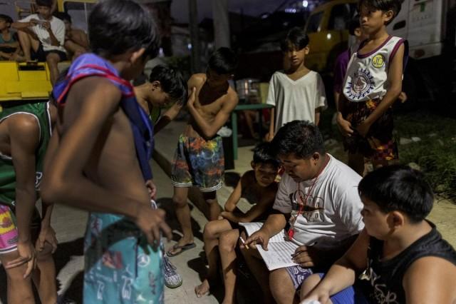 Boys check the starting lineup before a community league basketball game at a makeshift court in Quezon City, May 23, 2023. REUTERS/Eloisa Lopez