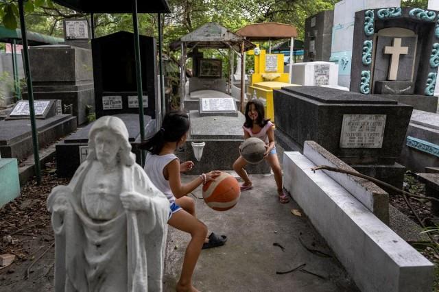 Girls practice dribbling basketballs at Manila South Cemetery in Makati, May 30, 2023.