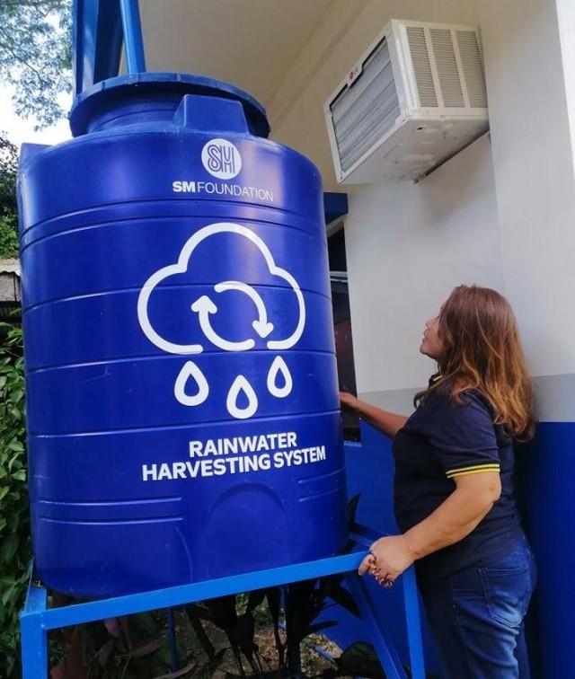 Midwife Narcisa Jagmis observes as the system collects rainwater from the gutters.