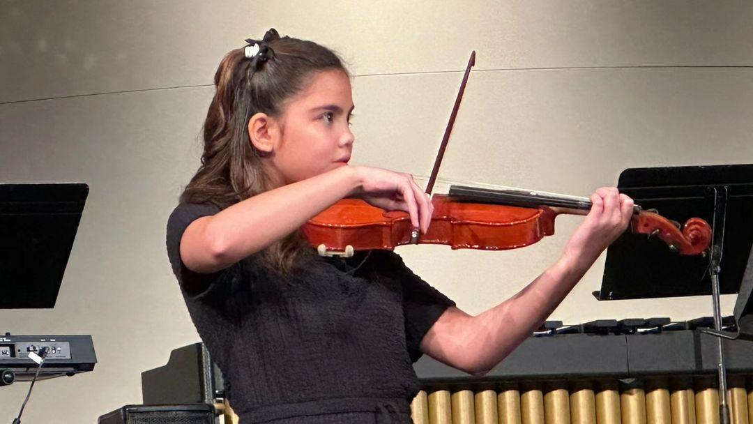 Doug and Chesca Kramer's daughter Scarlett tries out the violin