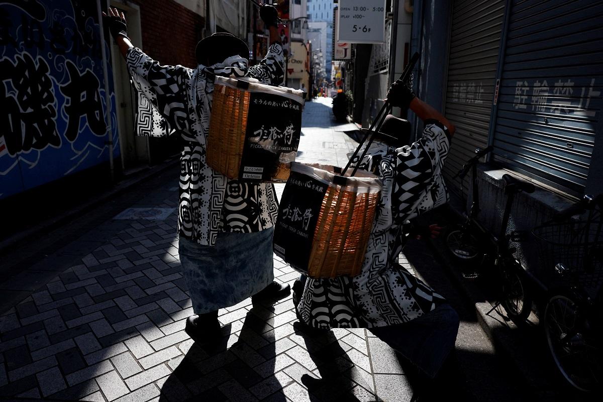 Keisuke Naka and Ikki Goto, members of Gomihiroi Samurai (trash-picking samurai) clad in denim yukata, pick up trash on the streets of Ikebukuro in the morning after Halloween while they perform samurai sword fighting by using their fire scissors in Tokyo, Japan November 1, 2023. REUTERS/Issei Kato