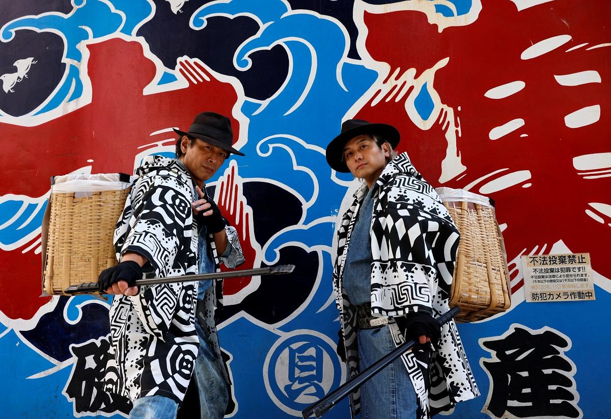 Keisuke Naka and Ikki Goto, members of Gomihiroi Samurai (trash-picking samurai) clad in denim yukata, pose for a photograph as they pick up trash on the street of Ikebukuro in the morning after Halloween in Tokyo, Japan November 1, 2023. REUTERS/Issei Kato