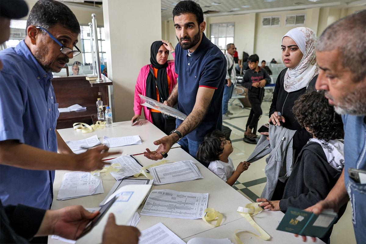 People present their travel documents to be checked at the terminal on the Palestinian side of the Rafah border crossing with Egypt in the southern Ga