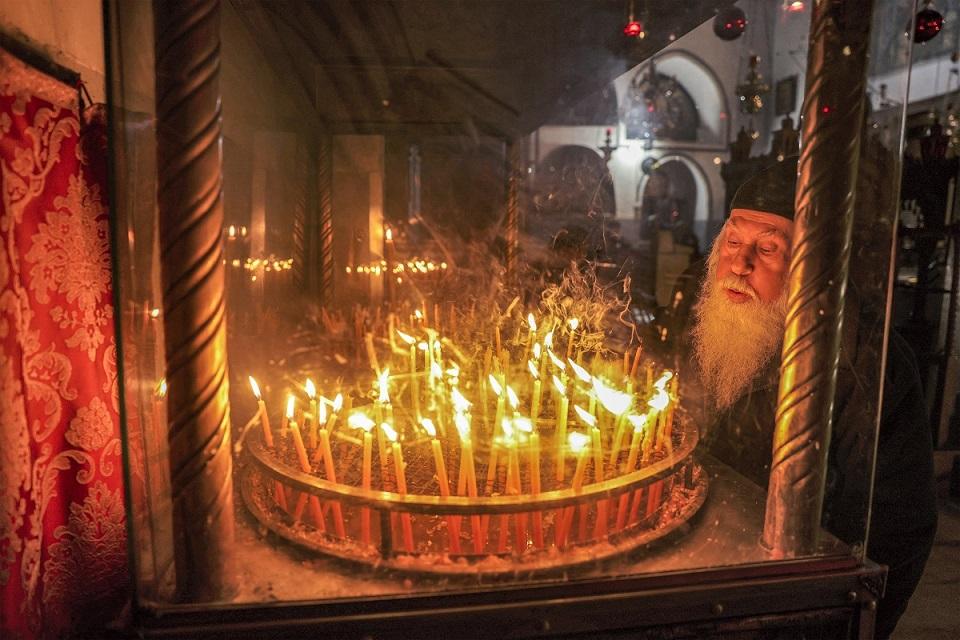 Christian worshipper lights a candle at the Church of the Nativity in Bethlehem, the occupied West Bank on Christmas Eve