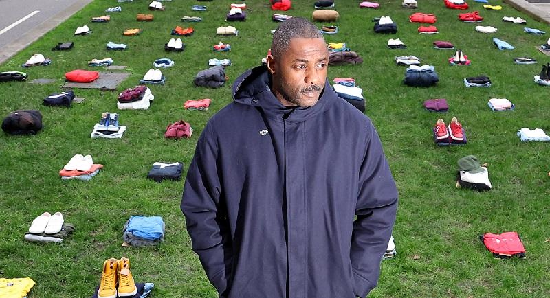 Idris Elba stands in front of a display of clothing representing victims of knife crime