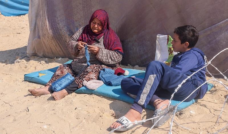 Gazan woman crafts warm clothes for displaced children