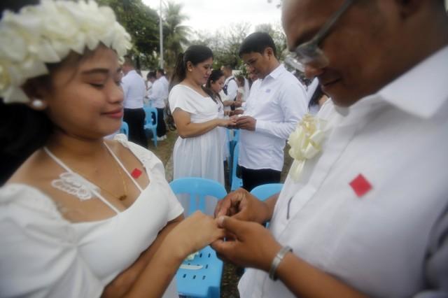 Couples exchange rings at the mass wedding. DANNY PATA