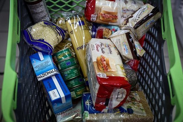 A shopping trolley is filled with food products at Caritas Emporium. REUTERS/ Guglielmo Mangiapane