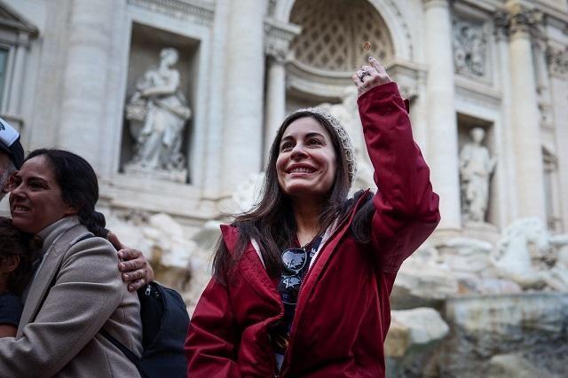 Yula Cole, from Brazil, throws a coin into the Trevi Fountain in Rome, Italy, February 16, 2024. REUTERS/ Guglielmo Mangiapane