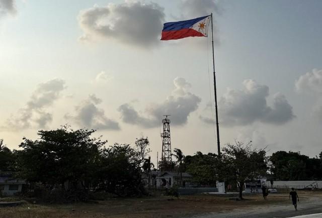 A Philippine flag rises high on Pag-asa Island, as residents are reminded during flag-raising ceremonies in military and civilian outposts that the place is part of the Philippine territory. JP SORIANO