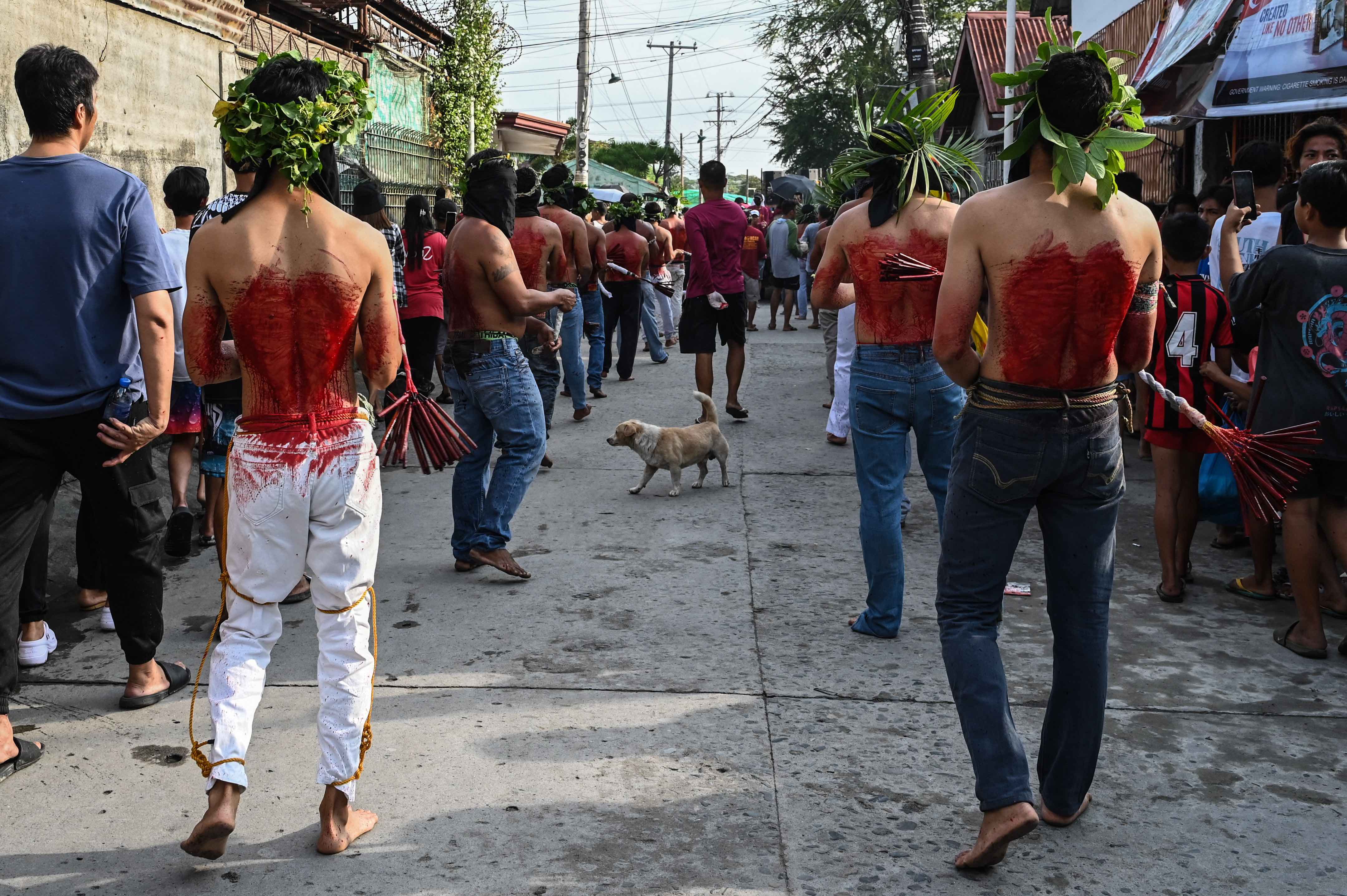 Penitents flagellate themselves during Good Friday as part of Holy Week celebrations in San Fernando, Pampanga province on March 29, 2024. (Photo by J