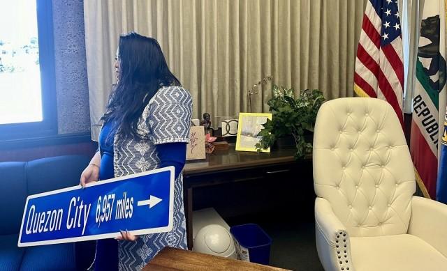 Manalo holds a highway sign showing the distance to Daly City's sister city, Quezon City. Ted Cordero/GMA Integrated News