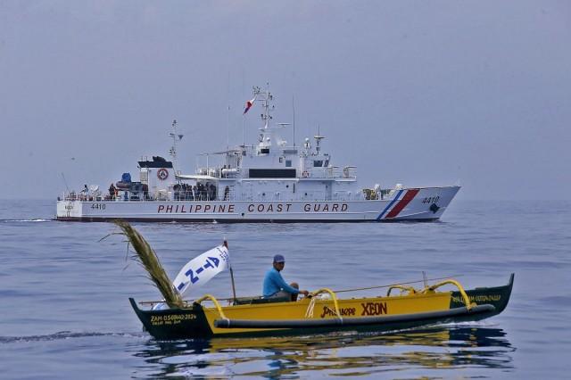 Watched over by the Philippine Coast Guard, a small fishing boat takes part in the Atin Ito civilian mission to Bajo de Masinloc (Scarborough Shoal) on Wednesday, May 15, 2024, amid China's aggression in the sea. DANNY PATA