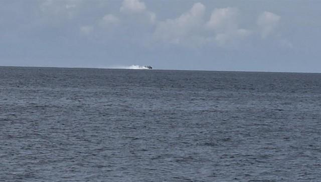 A Chinese hovercraft is seen on the horizon in Escoda Shoal while Filipino experts are conducting scientific research.