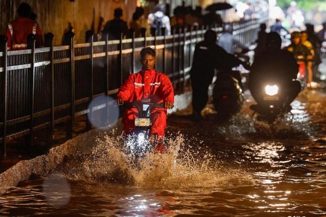 A delivery person rides an electric scooter in a waterlogged subway after heavy rains in Mumbai, India, July 8, 2024. REUTERS/ Francis Mascarenhas