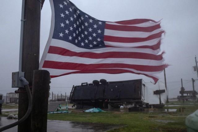 An American flag waves near a trailer home left overturned by Hurricane Beryl winds in Surfside Beach, Texas, July 8, 2024. REUTERS/ Adrees Latif