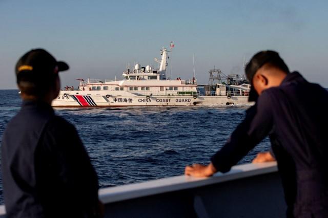 Members of the Philippine Coast Guard stand alert as a China Coast Guard vessel blocks their way to a resupply mission at Ayungin Shoal (Second Thomas Shoal) in the West Philippine Sea back in 2024. REUTERS/Adrian Portugal/File Photo