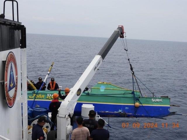 The Philippine Coast Guard (PCG) vessel BRP Sindangan hoists the FBCA John Robert out of the waters. Photo: PCG