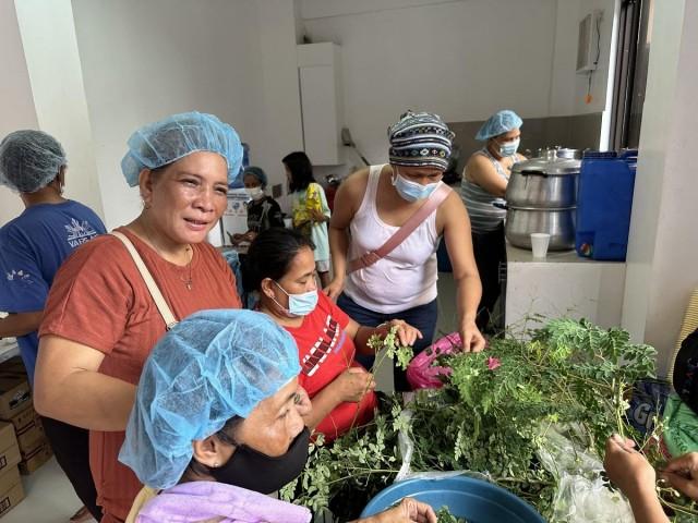 Mercy Absalon (in cloth cap) and her fellow Good Samaritans work in the evacuation center's kitchen on Thursday, July 25, 2024. Photos: Tina Panganiban-Perez/ GMA Integrated News