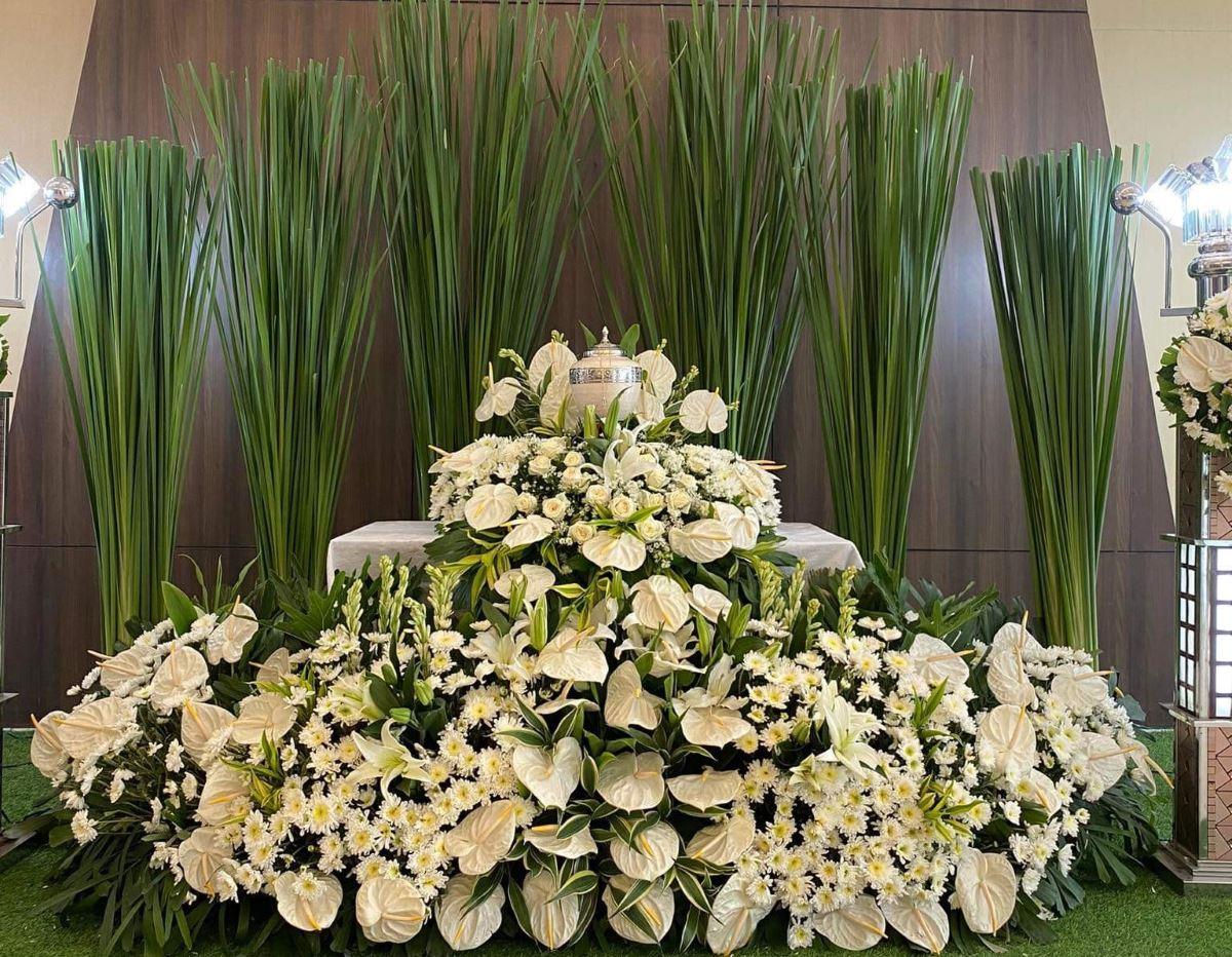 White flowers surround the urn containing the remains of beauty contestant Geneva Lopez at her wake in a funeral home in Minalin, Pampanga. 