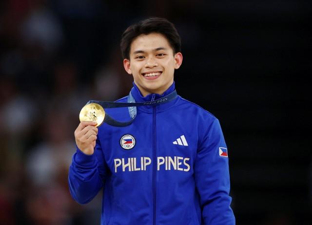 Paris 2024 Olympics - Artistic Gymnastics - Men's Vault Victory Ceremony - August 04, 2024. Gold medalist Carlos Yulo of the Philippines celebrates on the podium with his medal. REUTERS/Hannah Mckay