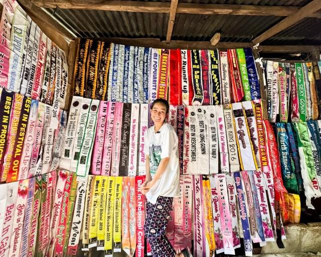 A young Rechel Hoco and the rows upon rows of sashes lined up across the walls of their old house. 'Pumapasok po ako ng high school sa araw, then pageant po sa gabi.' Contributed photo