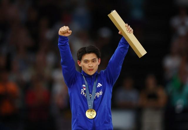 Paris 2024 Olympics - Artistic Gymnastics - Men's Vault Victory Ceremony -  August 04, 2024. Gold medalist Carlos Yulo of Philippines celebrates on the podium with his medal. REUTERS/Hannah Mckay