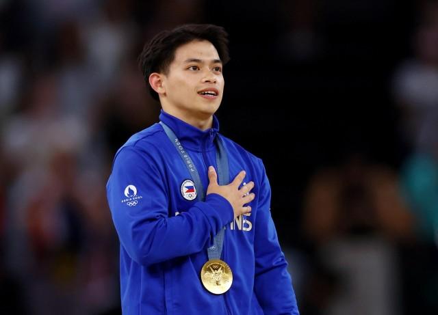 Paris 2024 Olympics - Artistic Gymnastics - Men's Vault Victory Ceremony - August 04, 2024. Gold medalist Carlos Yulo of Philippines celebrates on the podium with his medal. REUTERS/Hannah Mckay