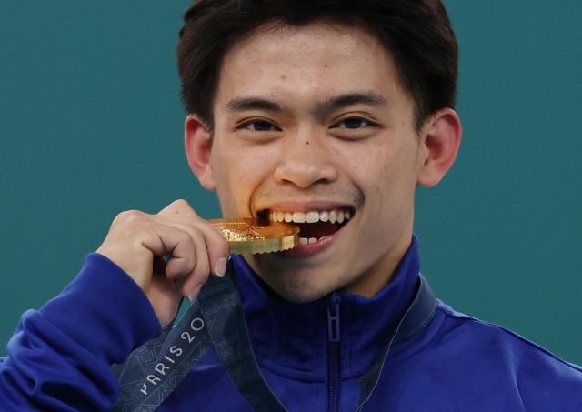 Paris 2024 Olympics - Artistic Gymnastics - Men's Vault Victory Ceremony - August 04, 2024. Gold medallist Carlos Edriel Yulo of Philippines celebrates on the podium with his medal. REUTERS/Mike Blake