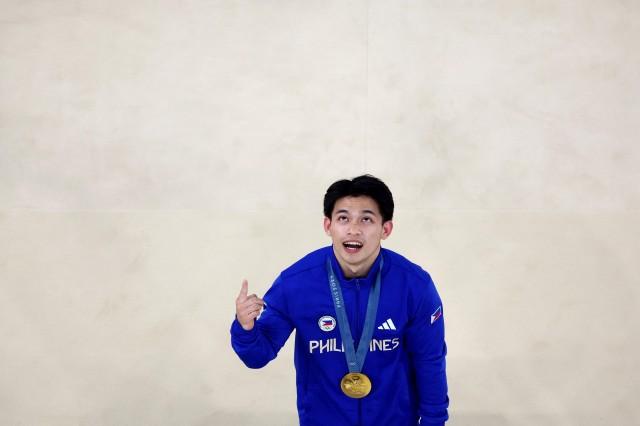 Paris 2024 Olympics - Artistic Gymnastics - Men's Vault Victory Ceremony - August 04. Gold medalist Carlos Yulo of Philippines celebrates with his medal on the podium. REUTERS/Athit Perawongmetha