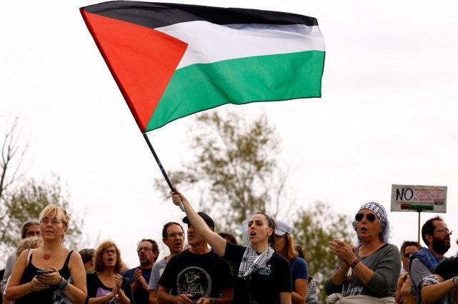 A demonstrator waves a Palestinian flag as people take part in a protest in front of Rheinmetall Expal Munitions, an arms manufacturer of the Rheinmetall group, to stop arms sales to Israel and to end military operations in the Gaza Strip and the Israeli-occupied West Bank in Navalmoral de la Mata, Spain, October 6, 2024. REUTERS/ Susana Vera