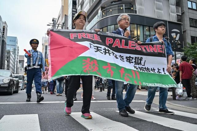 People participate in a protest march along a street in Tokyo on October 6, 2024, to demand an end to the conflict in Gaza, which has killed nearly 42,000 people. Richard A. Brook / AFP