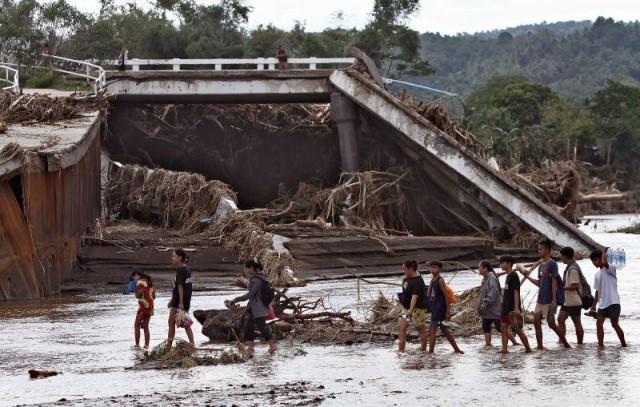 Some residents in Laurel, Batangas cross the Bugaan River on Saturday, October 26, 2024 after the bridge collapsed due to the impact of Severe Tropical Storm Kristine (international name: Trami). Photo: Danny Pata