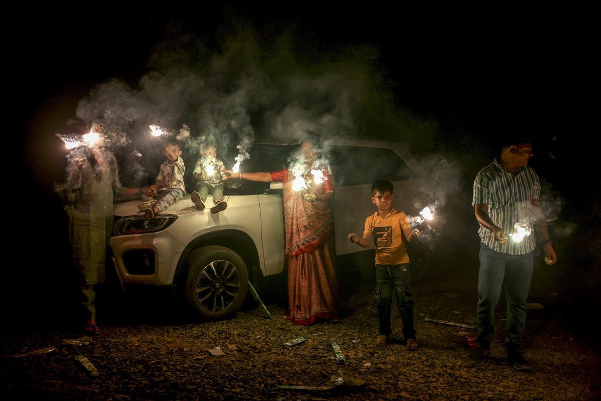 A family holds fireworks to celebrate Diwali, the Hindu festival of lights