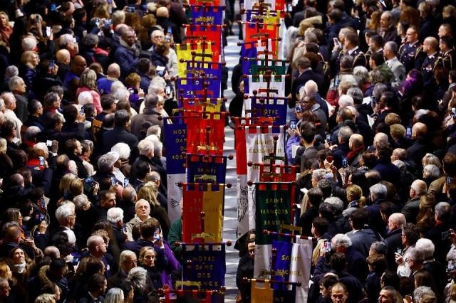 Representatives of all the parishes of Paris hold banners in honor of different saints during the inaugural Mass. REUTERS/ Sarah Meyssonnier/ Pool