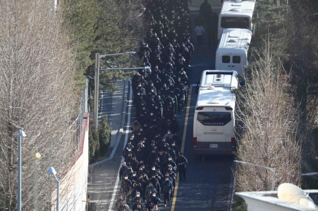 Police officers and investigators of the Corruption Investigation Office for High-ranking Officials leave the official residence of impeached South Korean President Yoon Suk Yeol, in Seoul, South Korea, January 15, 2025. REUTERS/Kim Hong-Ji