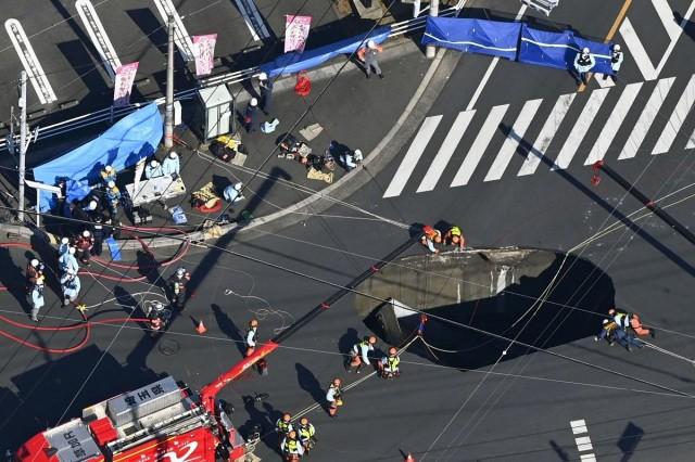 This photo taken from a Kyodo News helicopter on Jan. 28, 2025, shows the original size of the ge sinkhole at an intersection in Yashio, Saitama Prefecture, near Tokyo. The hole is 10 meters wide and six meters deep, with fire authorities rescuing at least one person following the incident. KYODO via Reuters