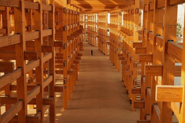 A man walks under the Grand Ring, the largest wooden architectural structure according to Guinness World Records, during a media tour before the official opening of Expo 2025 in Osaka, Japan March 26, 2025. REUTERS/ Tom Bateman