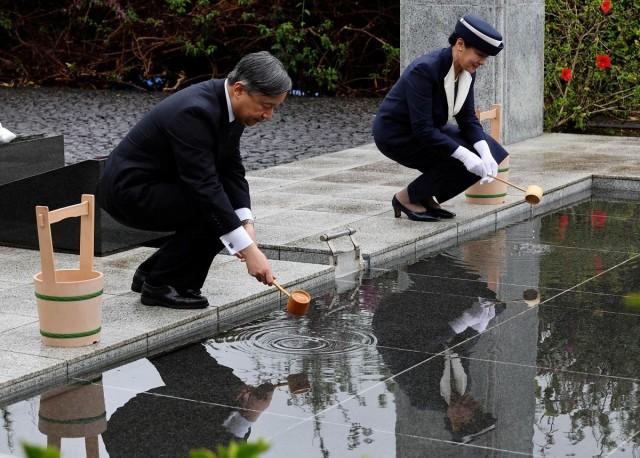 Emperor Naruhito and Empress Masako pour water on requiem hill. REUTERS/ Kim Kyung-Hoon/ Pool
