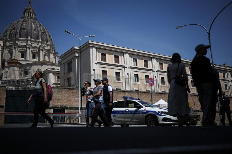 People walk near the Casa Santa Marta in Vatican