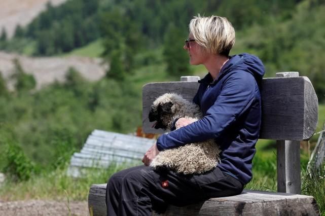 A woman holds a sheep, which was carried by helicopter in Wiler, near Blatten, Switzerland, May 29, 2025. REUTERS/ Stefan Wermuth