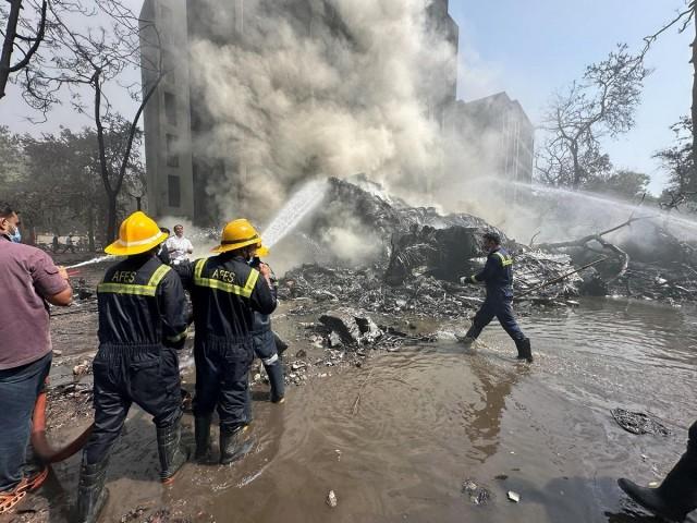 Rescue team members work as smoke rises at the site where an Air India plane crashed in Ahmedabad, India, June 12, 2025. REUTERS/ Amit Dave