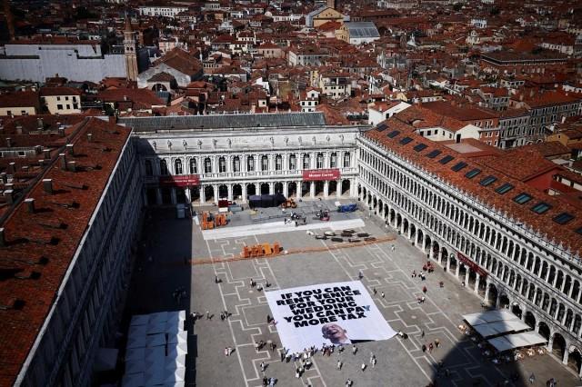 A large banner against Amazon founder Jeff Bezos lies on the ground, placed by Greenpeace Italy activists and UK activist group Everyone Hates Elon, in St. Mark's Square, ahead of the expected wedding of Bezos and Lauren Sanchez, in Venice, Italy, June 23, 2025. REUTERS/ Yara Nardi