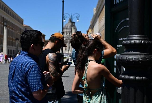 People fill up water bottles at a fountain at Piazza Pio on a hot summer day, in Rome near the Vatican on June 28, 2025. Italy's health ministry warned of soaring temperatures across the country, issuing a red alert for 21 cities including Rome, Milan, and Venice. Tiziana Fabi/ AFP