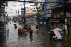 Residents wade through flood amid monsoon rains