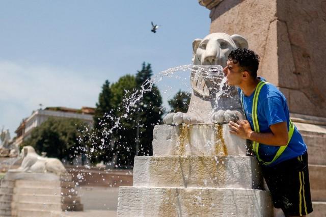 A man cools off with water at Piazza del Popolo during a heatwave in Rome, Italy, July 2, 2025. REUTERS/ Antonio Denti