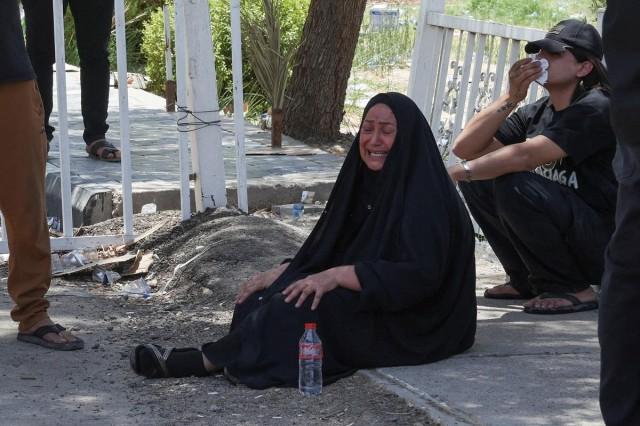 A woman mourns outside the forensic medicine department of a hospital following a massive overnight fire at a shopping center, which killed dozens of people, in al-Kut, Wasit province, Iraq, July 17, 2025. REUTERS/ Ahmed Saad