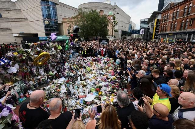 People gather around tributes at the Black Sabbath Bridge, named in honor of the heavy metal band, on the day of the funeral cortege of Ozzy Osbourne, its former frontman, in Birmingham, Britain, July 30, 2025. REUTERS/ Jack Taylor