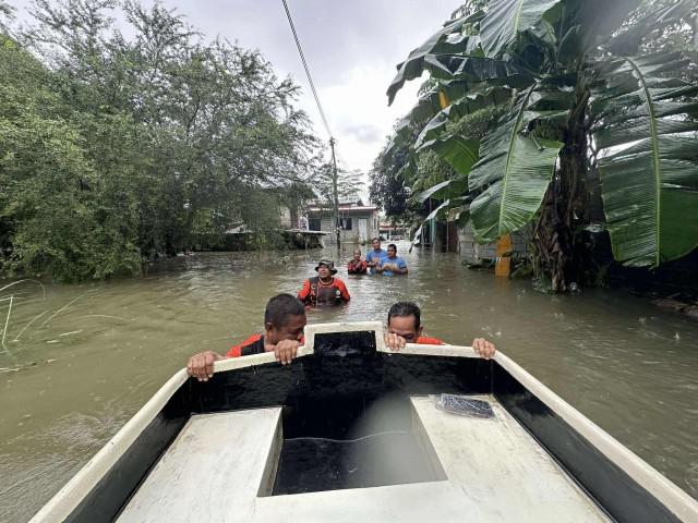 Rescuers wade through chest-deep floodwaters in Barangay Lasip, Calasiao, Pangasinan, on Tuesday, July 22, 2025. COURTESY: Calasiao Information Office via GMA Regional TV One North Central Luzon