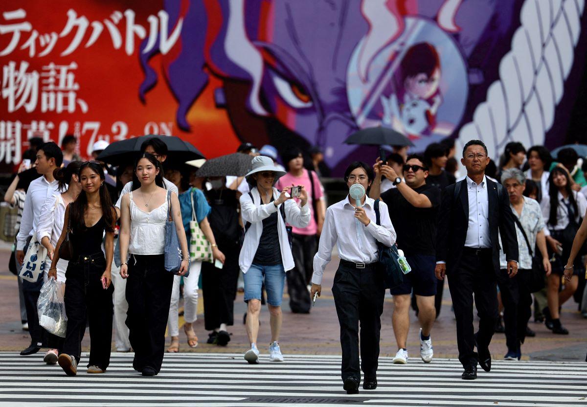 Passersby walk at Shibuya Crossing in Tokyo, Japan